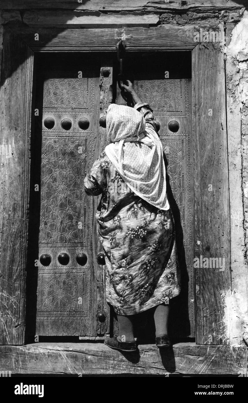 Woman locking door of Zindan, Bukhara Stock Photo
