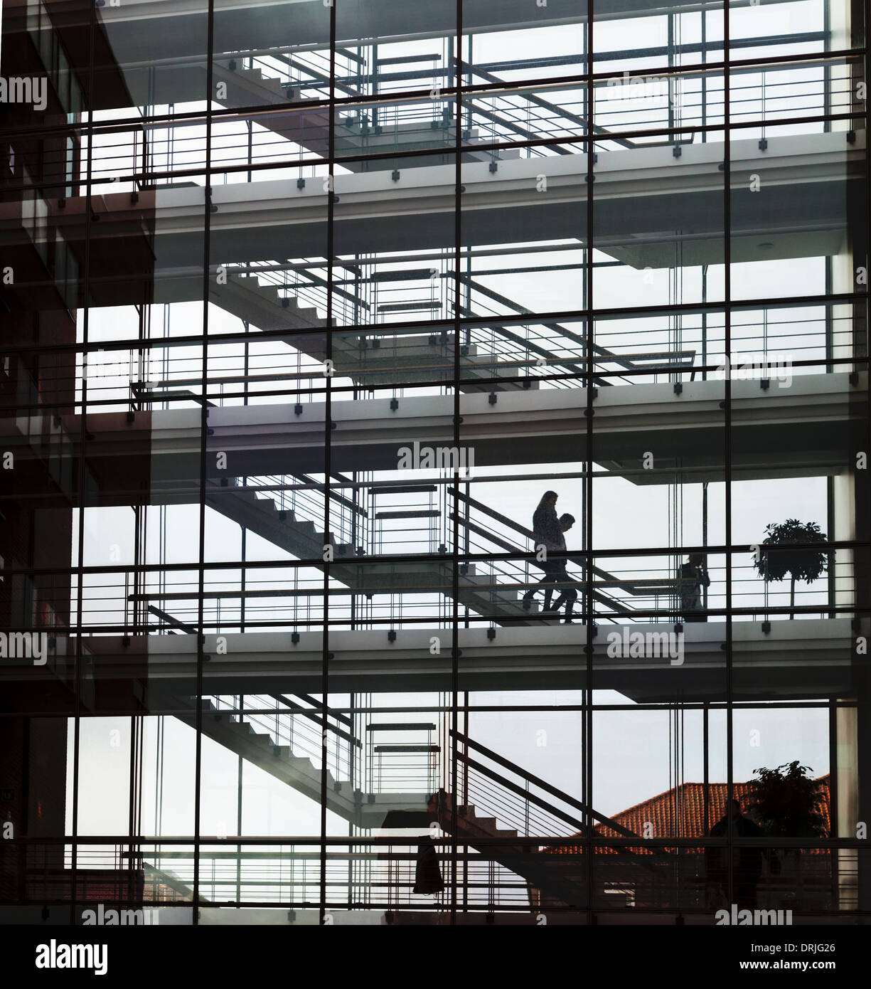 silhouette of stairs and walkways in glass walled building Stock Photo