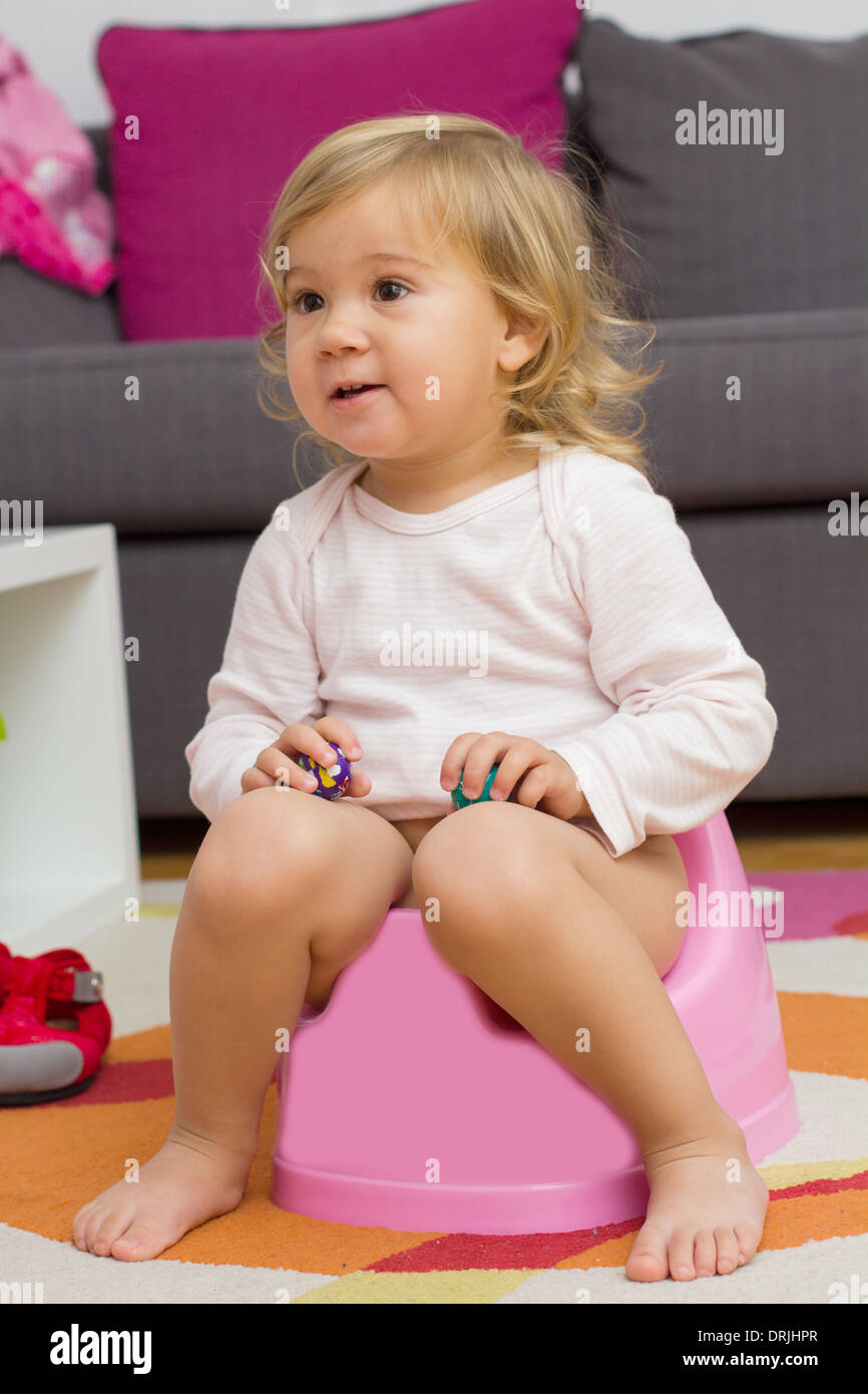 Little girl sitting on the potty at home Stock Photo Alamy
