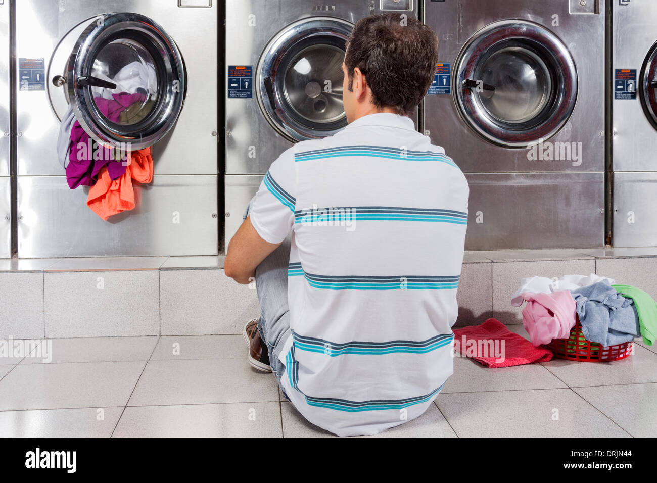 Man Sitting In Front Of Washing Machines Stock Photo Alamy