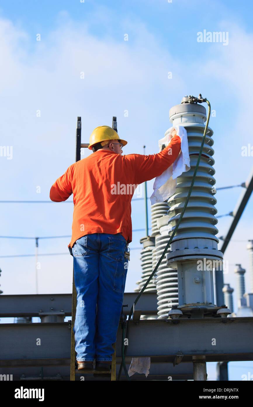 Power engineer cleaning a fluid filled high voltage insulator
