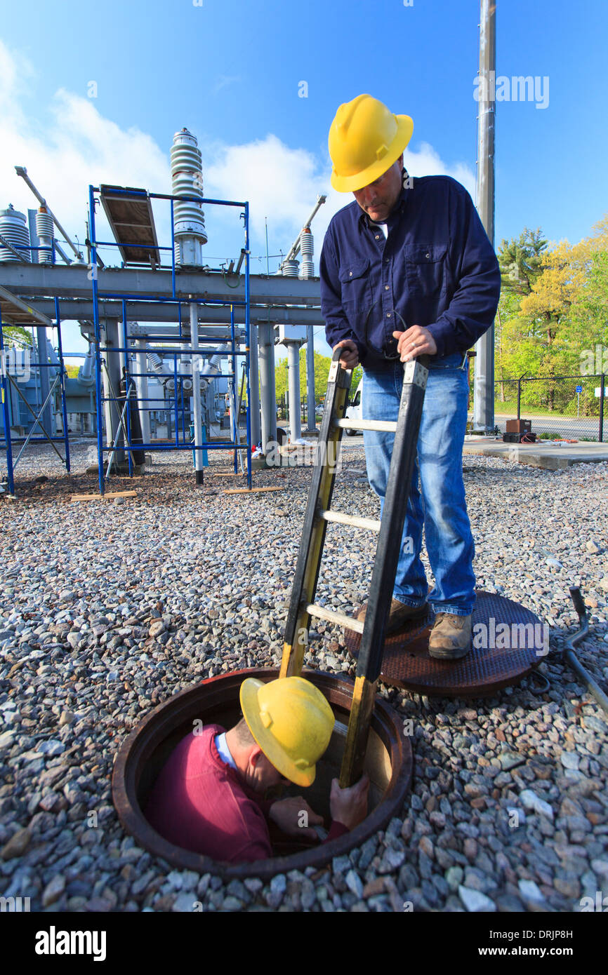 Power engineer entering manhole at a high voltage power distribution