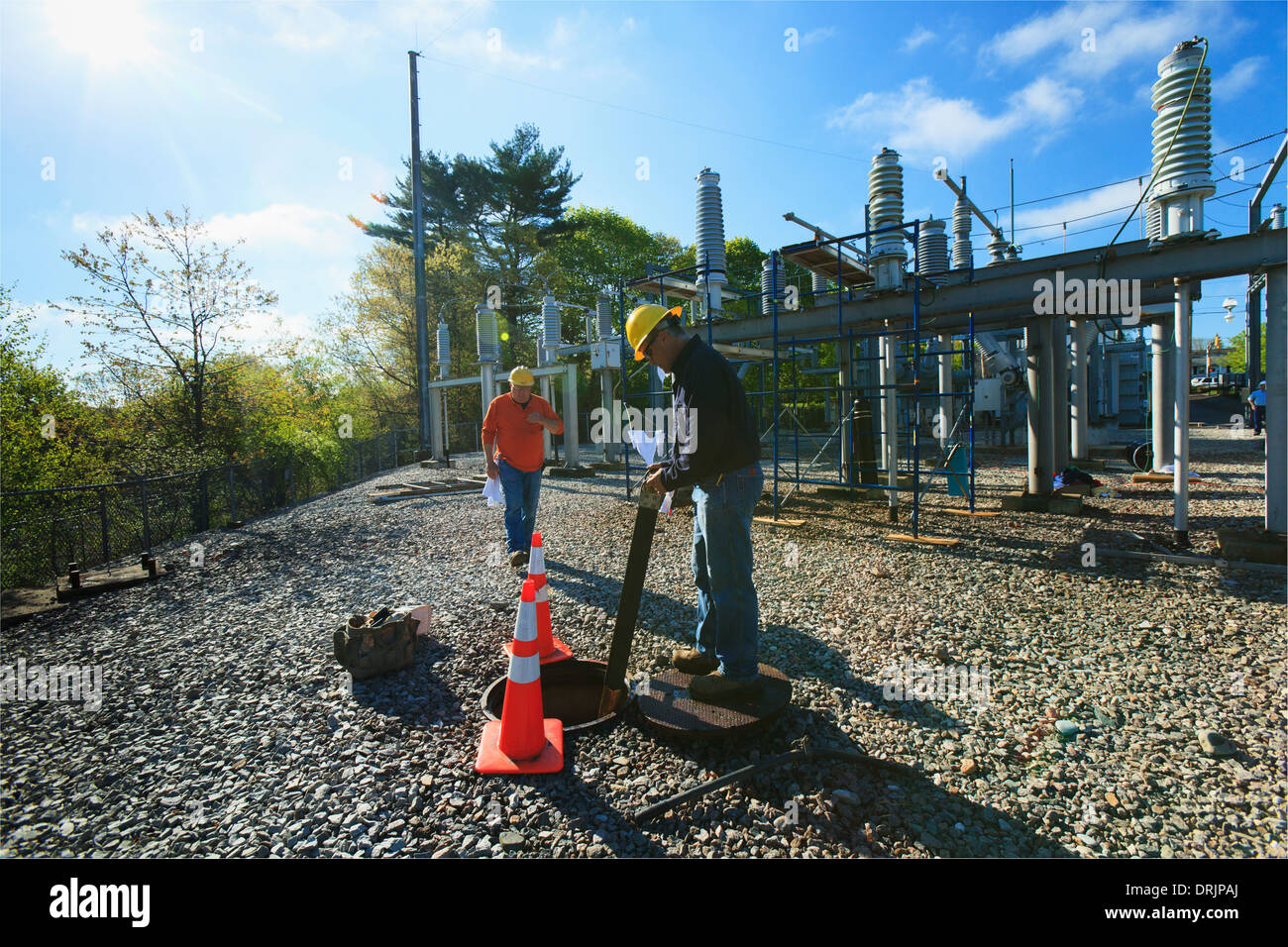 Power engineers working at high voltage power distribution station