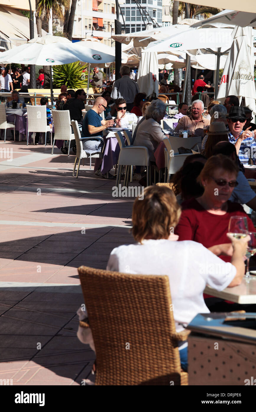 Cafe tables full of people on beachfront of Estepona Costa del Sol Spain Stock Photo
