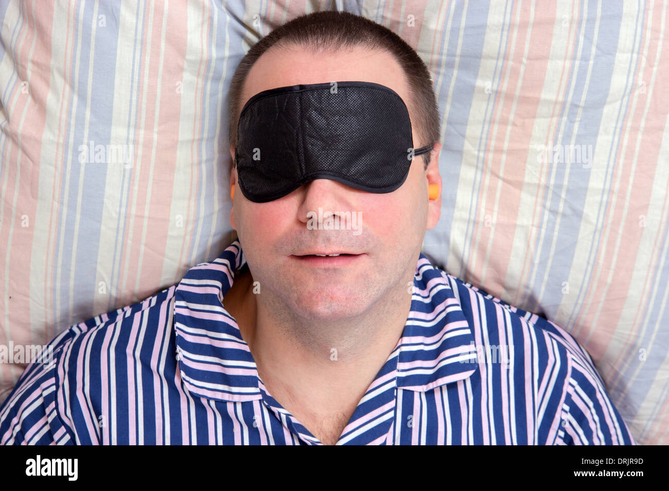 man sleeping with a mask on eyes Stock Photo