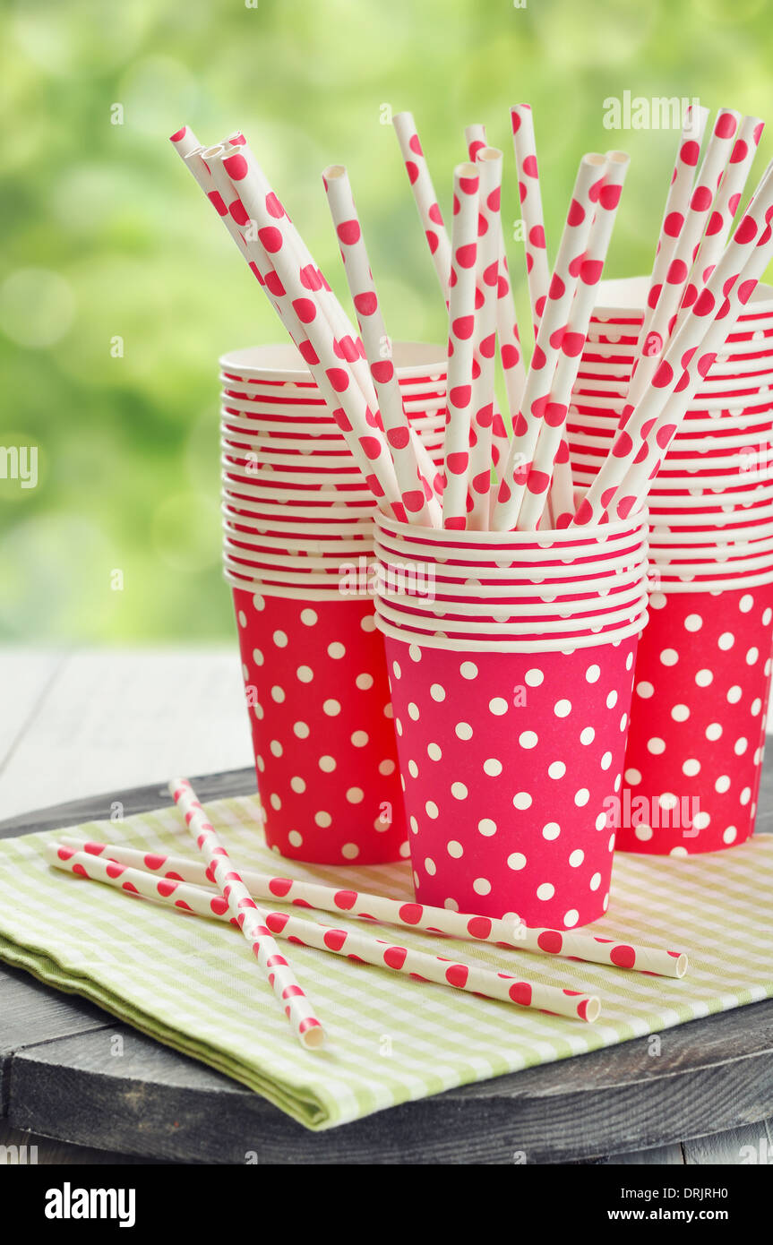 Red paper cups and striped straws for birthday party. Stock Photo