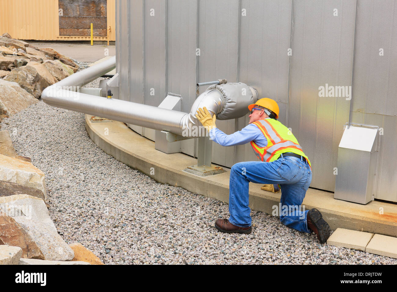 Engineer examining pipeline of water storage tank at electric power