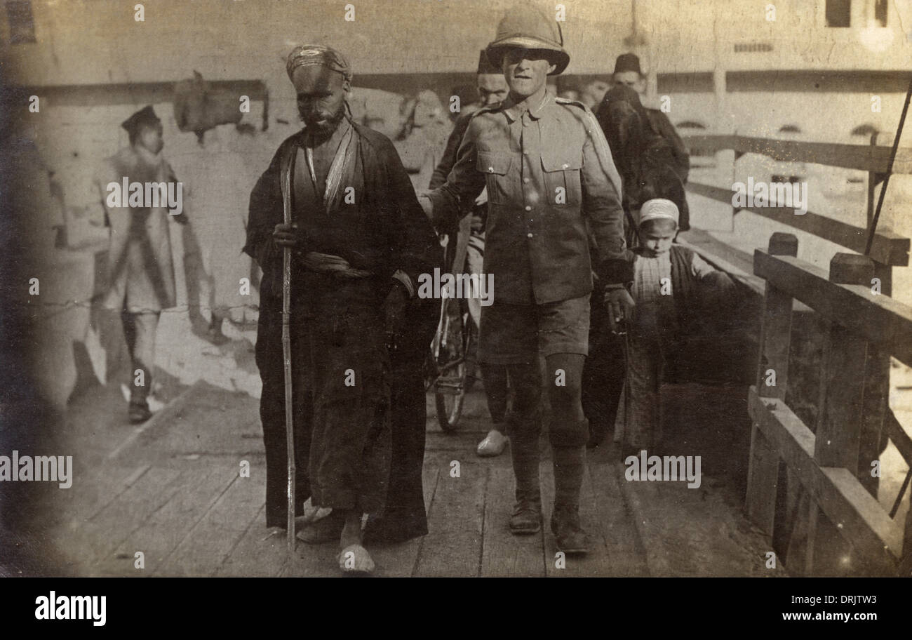 Egypt - British Soldier escorting an old blind Arab man Stock Photo