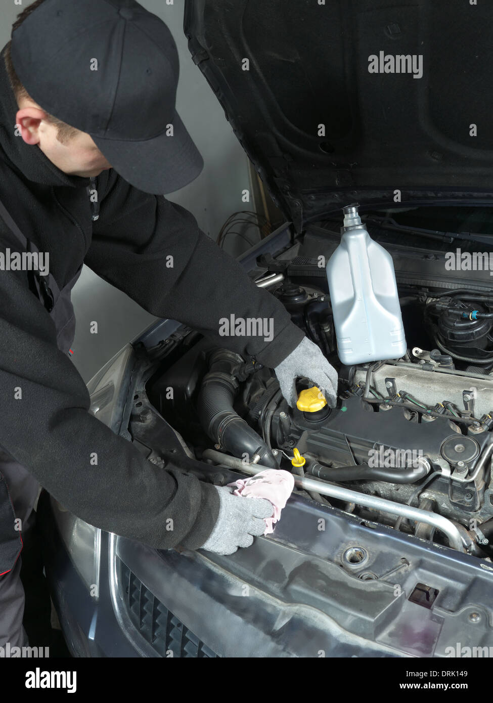 Auto mechanic unscrewing oil filler cap Stock Photo