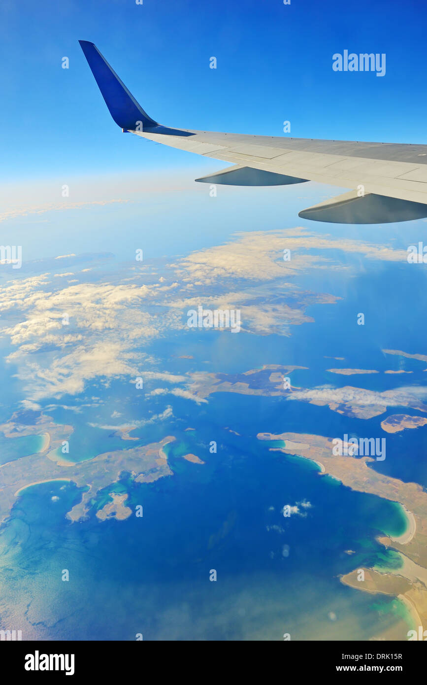 Wing of an airplane over ocean Stock Photo