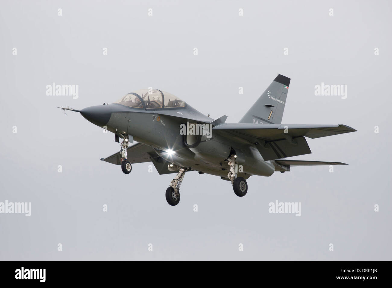 military 'jet airplane' on  landing finals at airport in england with wheels and flap down against clear neutral sky background Stock Photo