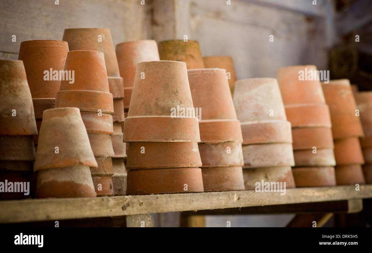 Terracotta plants pots stacked on a potting shed shelf. Stock Photo