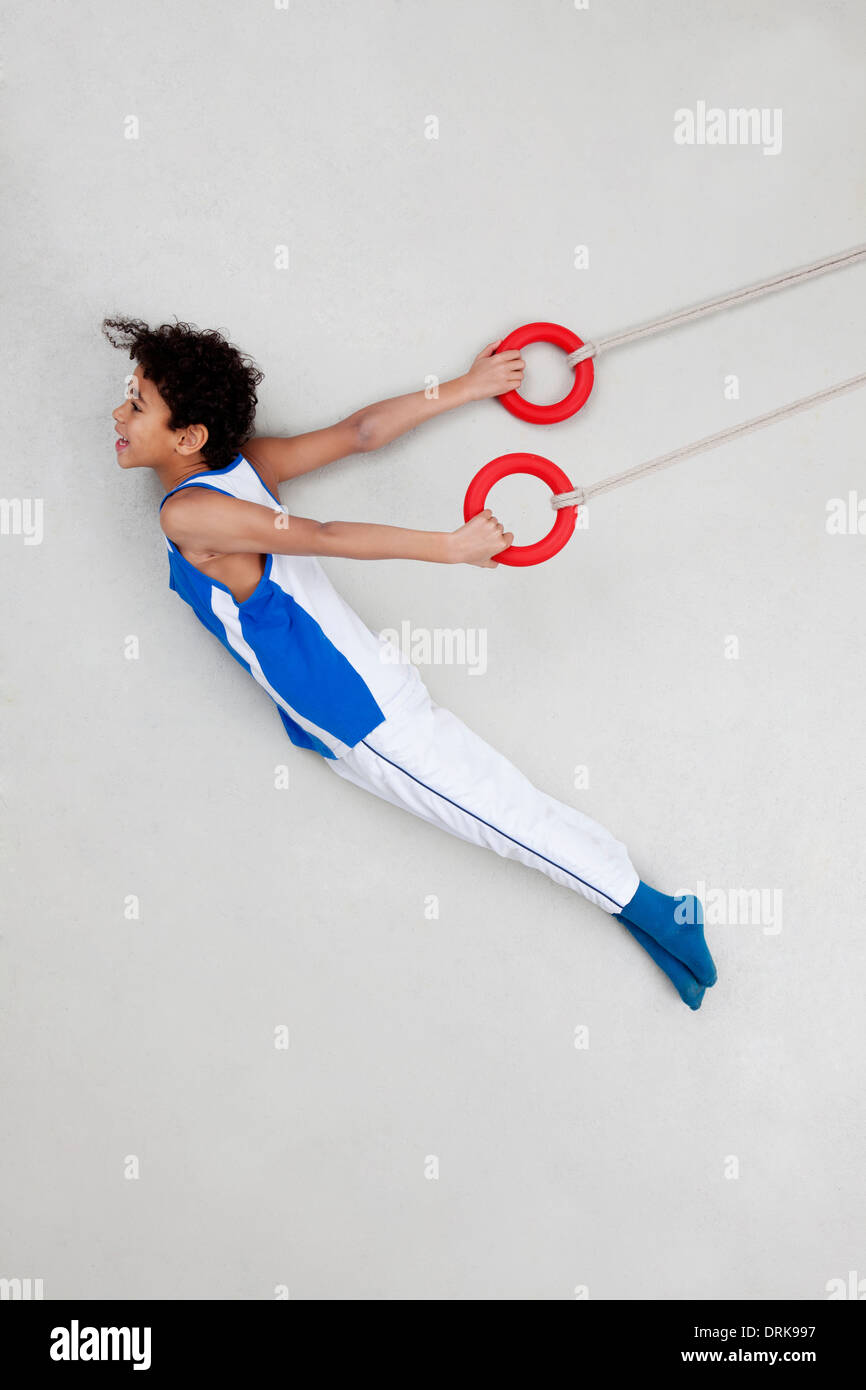 Boy exercising on rings Stock Photo - Alamy