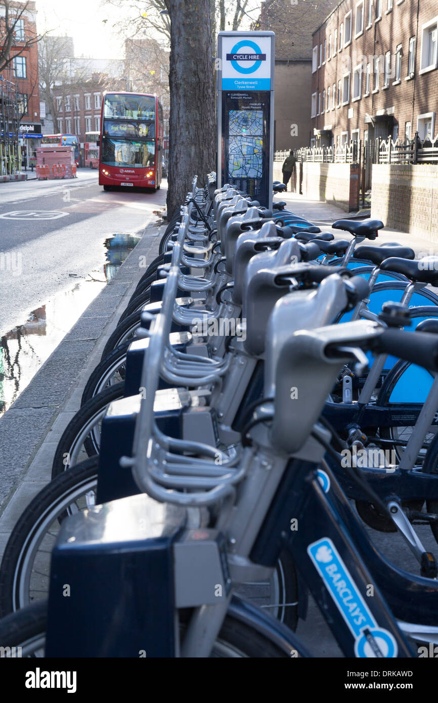 Cycle hire scheme in London, Boris bikes in rack. London bus approaching. London transport. Stock Photo