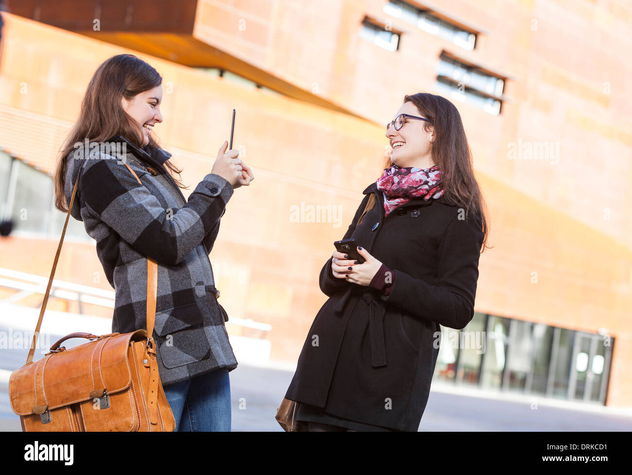 Two young women using digital tablet outdoors Stock Photo - Alamy