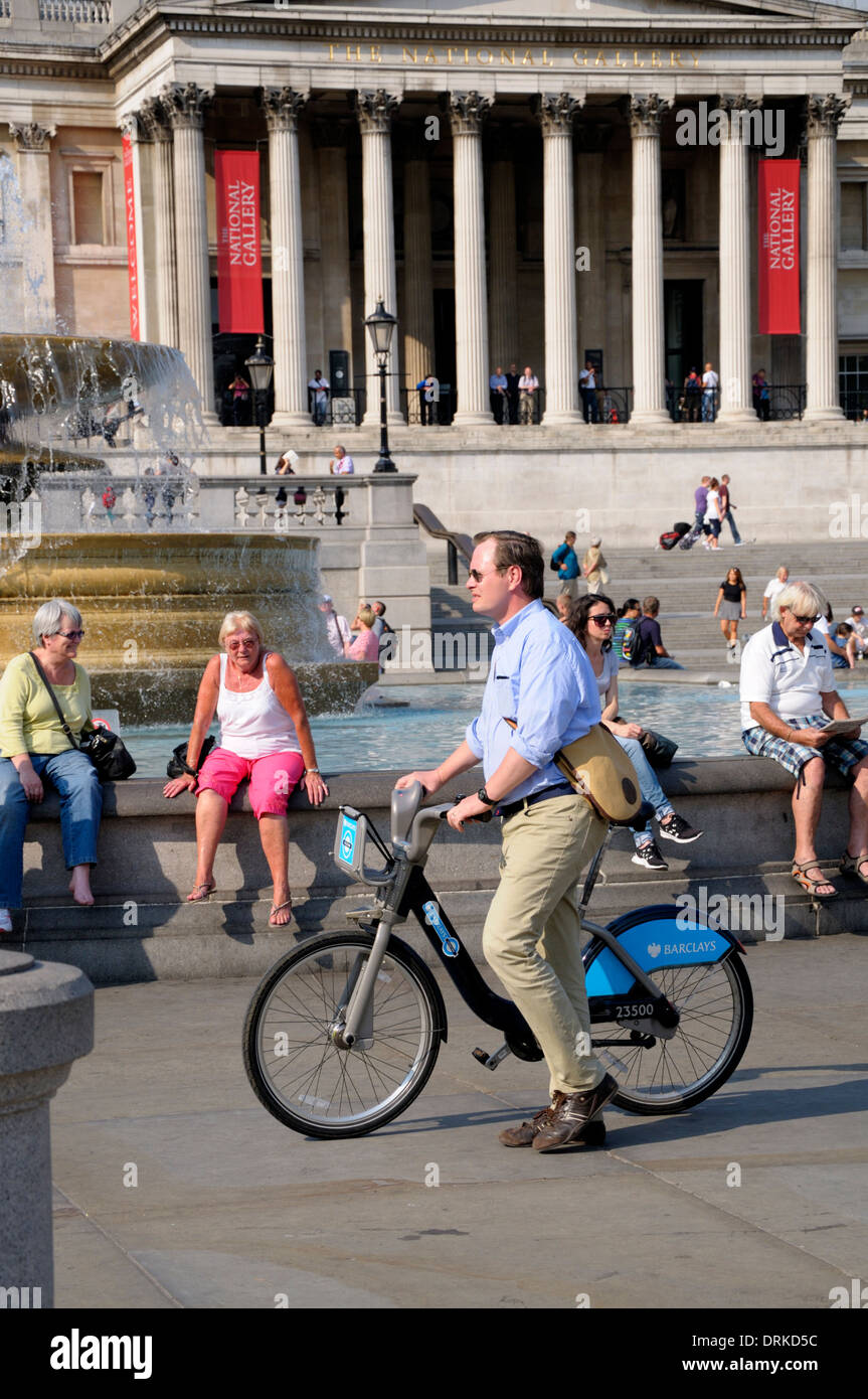 London, England, UK. Man pushing 'Boris Bike' / Barclay's rental cycle