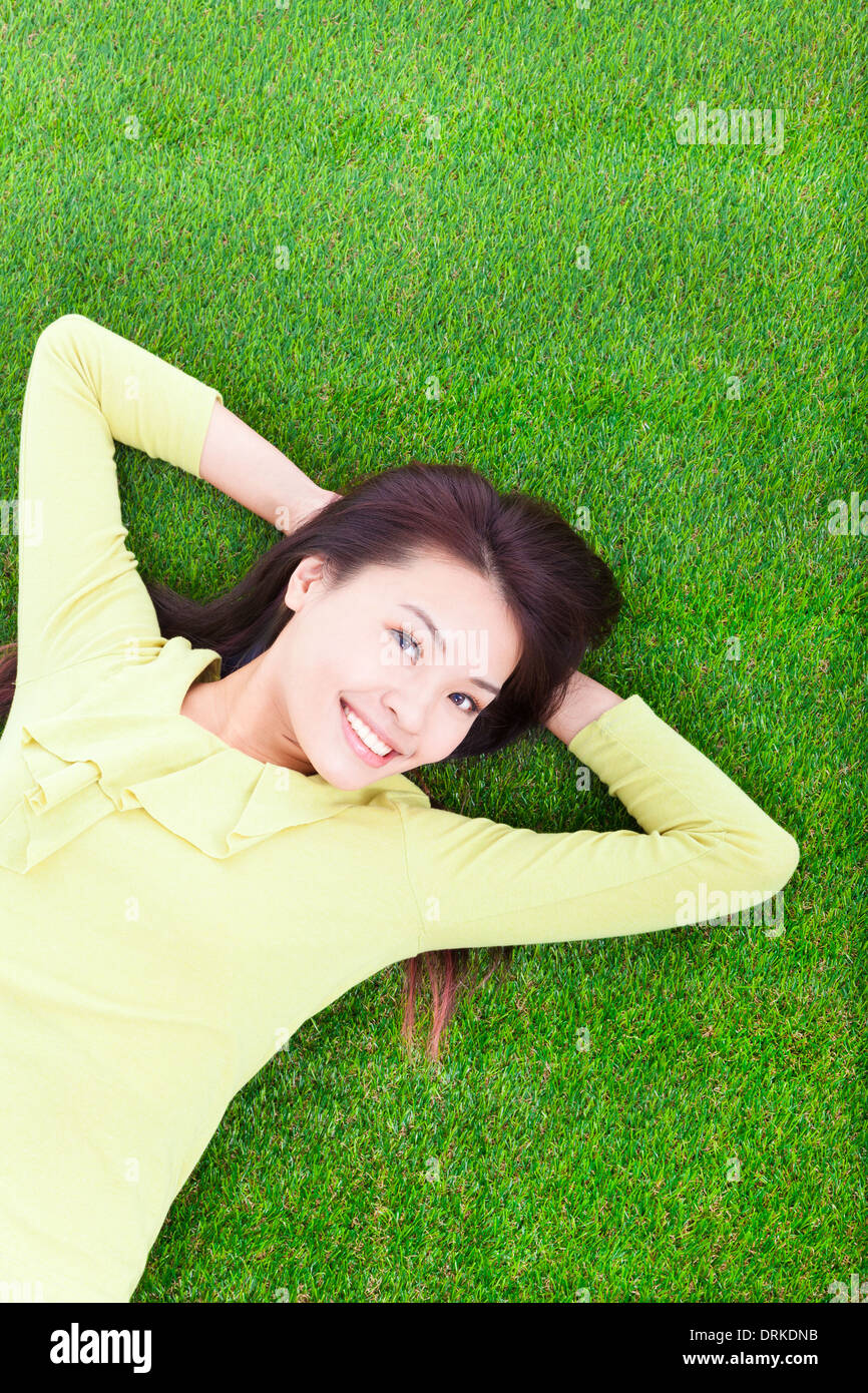 beautiful young woman laying down on grassland in park Stock Photo