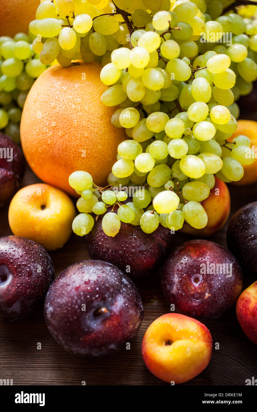 still life with fresh and wet fruits, selective focus on nearest plum Stock Photo