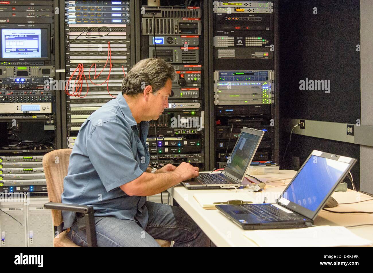 Dolby Atmos engineer Kevin Perry working at his laptop. Perry is sitting in the screening room of the audio company's headquarters in San Francisco, surrounded by sophisticated high-tech equipment for superior movie experiences. - 2013. Stock Photo