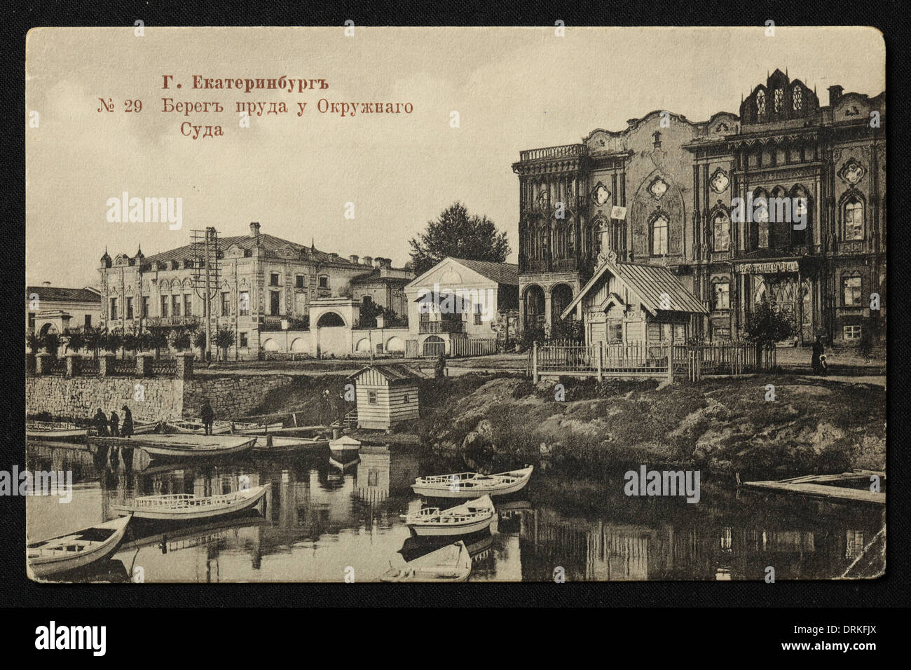 Tarasovskaya Embankment of the Iset River near the District Court in Yekaterinburg, Russian Empire. Black and white vintage photograph by Russian photographer Veniamin Metenkov dated from the beginning of the 20th century issued in the Russian vintage postcard published by Veniamin Metenkov himself in Yekaterinburg. Text in Russian: Yekaterinburg. Bank of the pond near the District Court. The Iset River forms the City Pond (Gorodskoy Pond) in the city centre of Yekaterinburg. The District Court also known as Sevastianov House or the Trade Union House is the architectural monument from the 19th Stock Photo