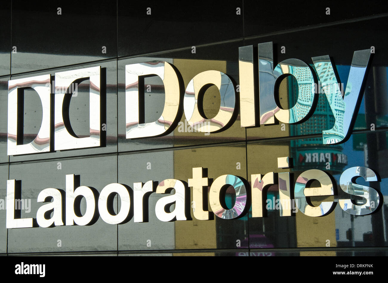 Dolby Laboratories logo on the outside wall of the company's 475 Brannan building in San Francisco. A parking garage on the other side of the street is reflected in the logo. - 2013. Stock Photo