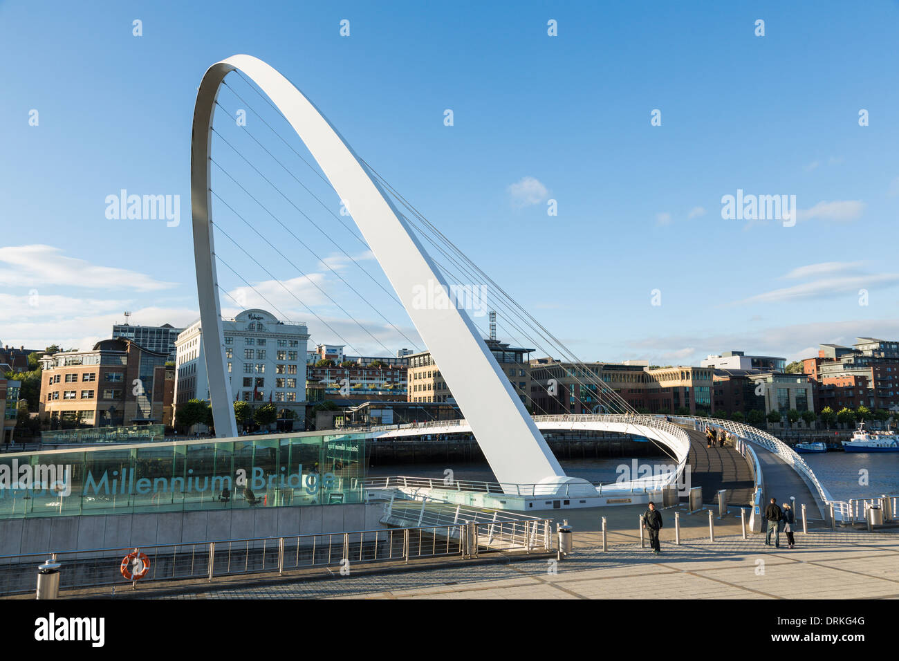 People walk Gateshead Millennium Bridge, Newcastle on Tyne, England Stock Photo