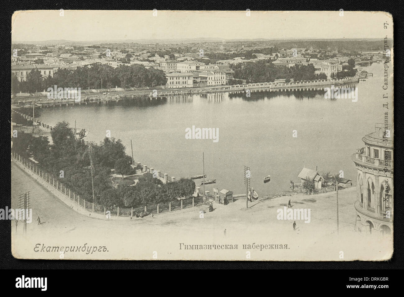 The City Pond (Gorodskoy Pond) on the Iset River in Yekaterinburg, Russian Empire. Black and white vintage photograph by an unknown photographer dated from the beginning of the 20th century issued in the Russian vintage postcard published by D.G. Sandler, Perm, Russia. Text in Russian: Yekaterinburg. Gimnazicheskaya Embankment (Gymnasium Embankment). Courtesy of the Azoor Postcard Collection. Stock Photo