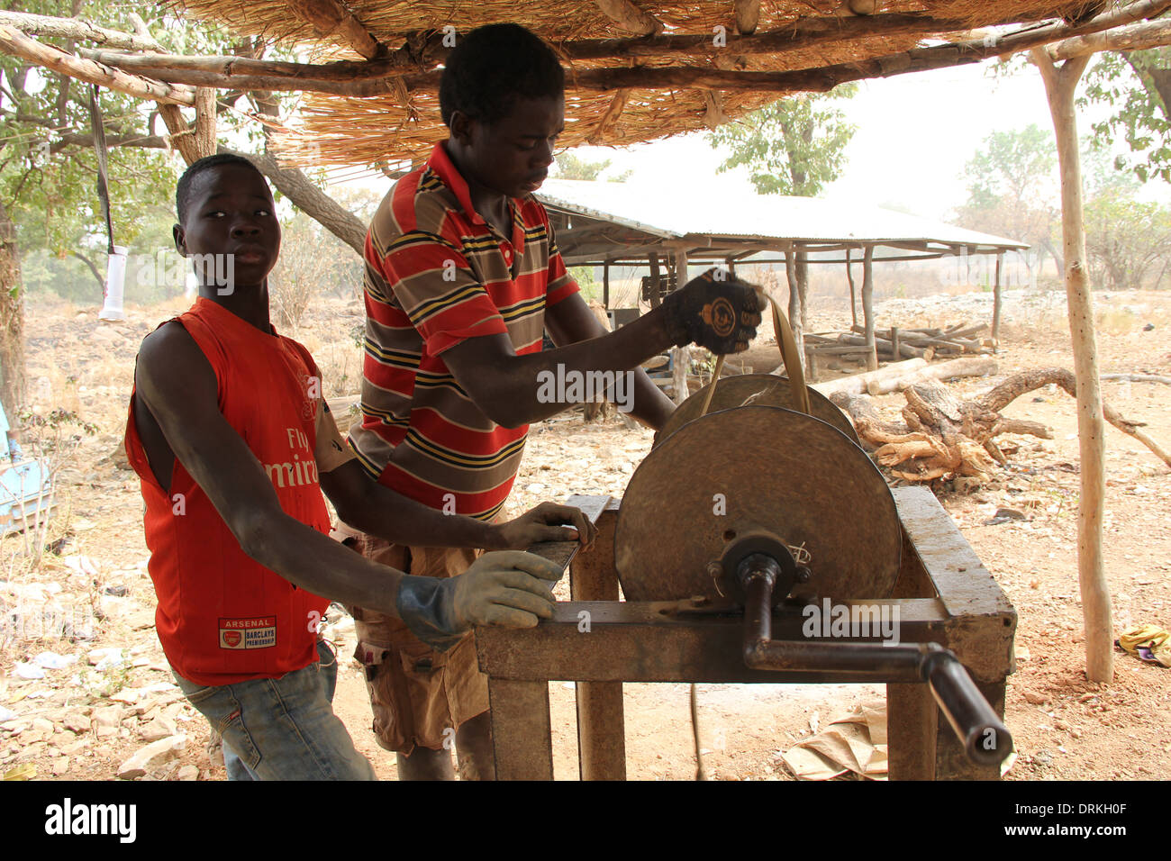 Two young men working a lathe in village workshop, Ghana Stock Photo