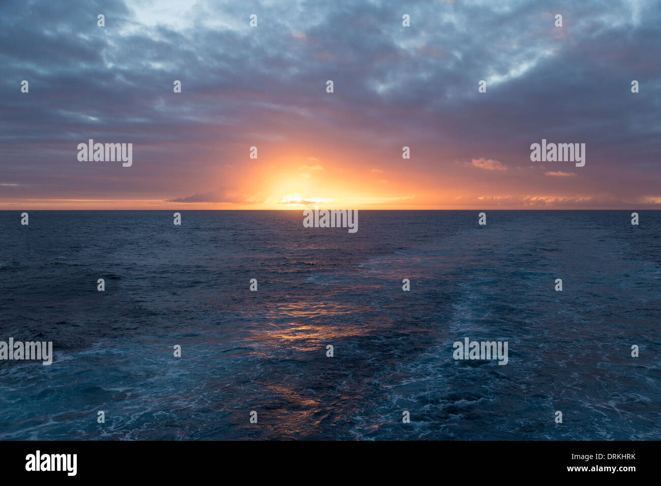 Sunrise and wake from ship at sea Stock Photo