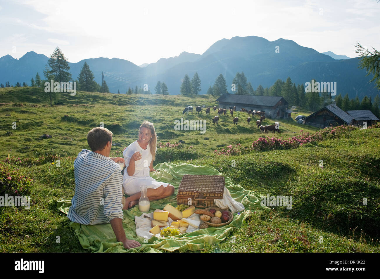 Austria, Salzburg State, Altenmarkt-Zauchensee, couple having a picnic on alpine meadow Stock Photo