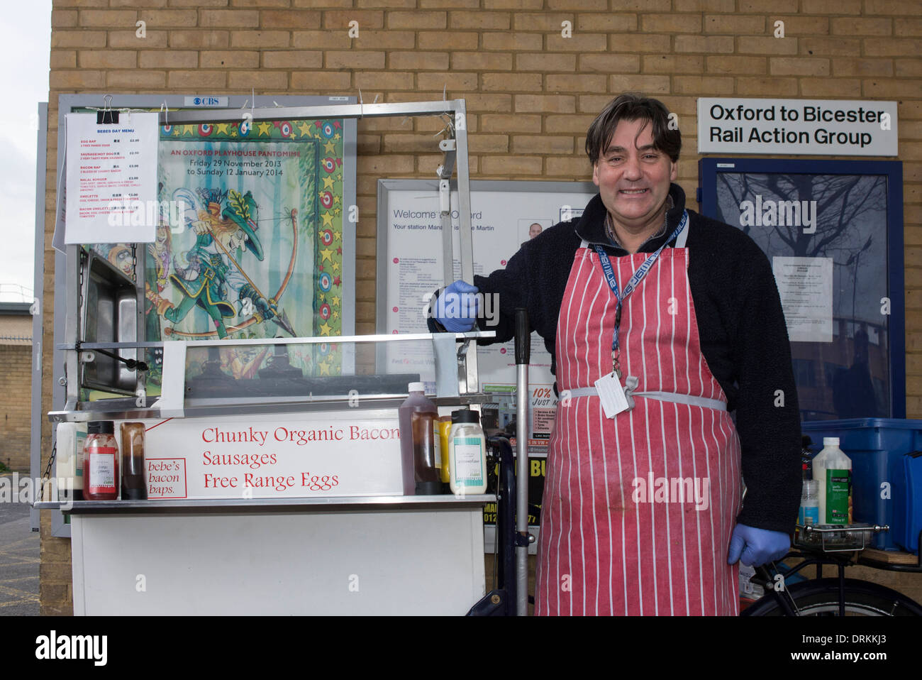 Smiling middle aged man selling organic fast food from hotplate on bicycle at Oxford, UK, railway station Stock Photo