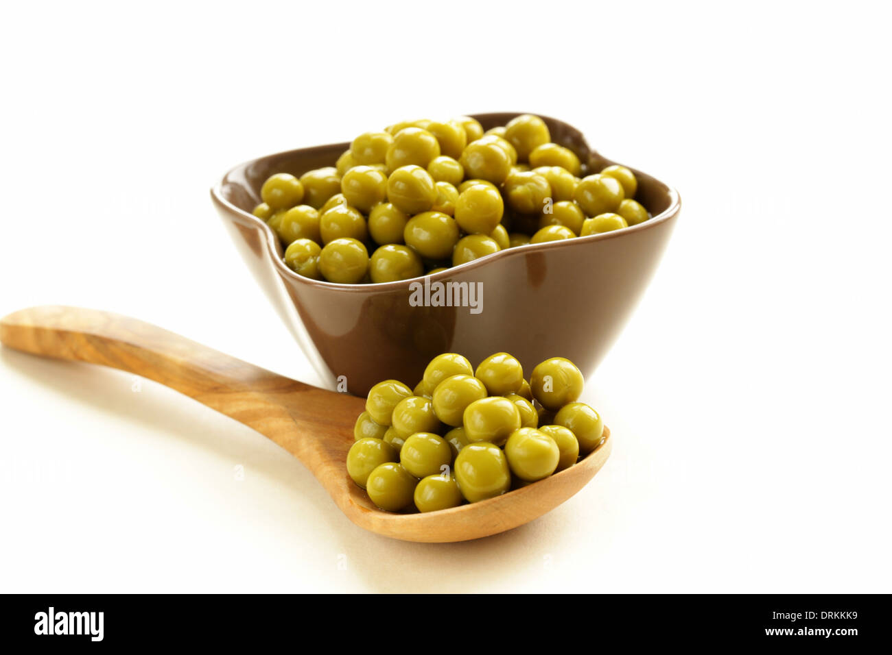 canned green peas in a wooden spoon Stock Photo