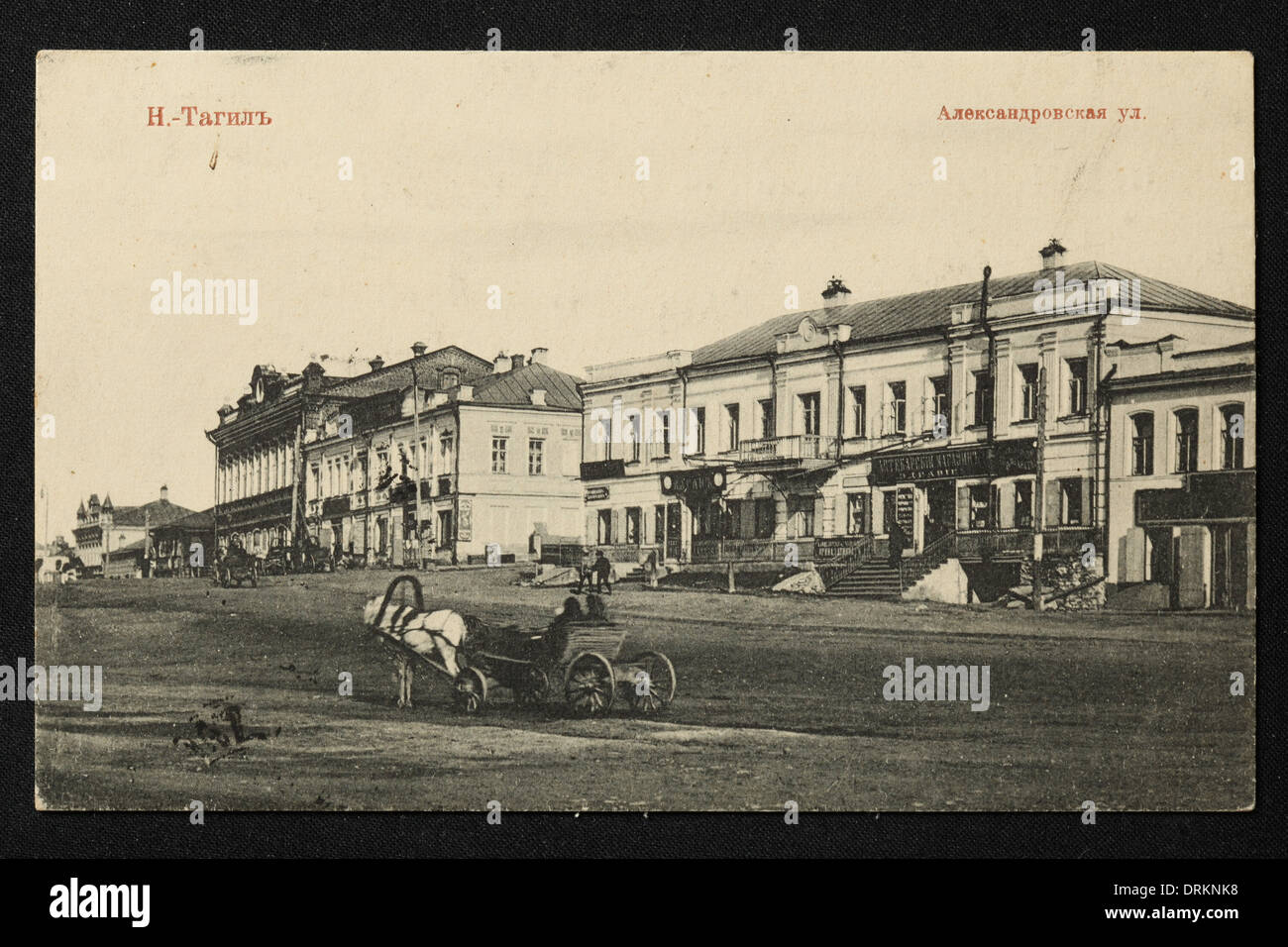 Alexandrovskaya Street in the town of Nizhny Tagil in the Ural Mountains, Russian Empire. Black and white vintage photograph by an unknown photographer dated from the beginning of the 20th century issued in the Russian vintage postcard published by M.A. Akhaimova. Text in Russian: Nizhny Tagil. Alexandrovskaya Street. Nizhny Tagil is a city in Sverdlovsk region, Russia, located some 120 km from Yekaterinburg. Courtesy of the Azoor Postcard Collection. Stock Photo