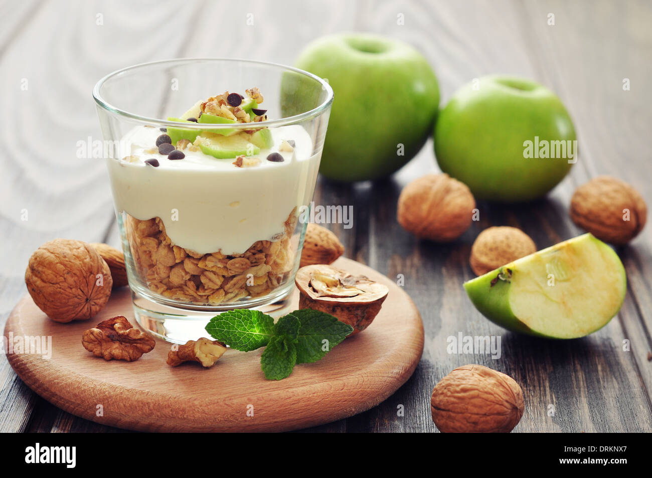 Homemade dessert with apple, nuts, yogurt and granola in glasses Stock Photo