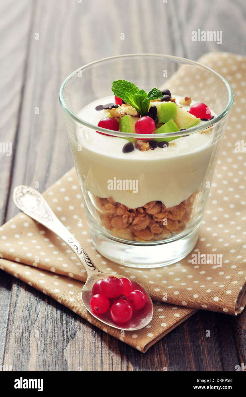 Homemade dessert with apple, nuts, cranberry, yogurt and granola in glasses Stock Photo