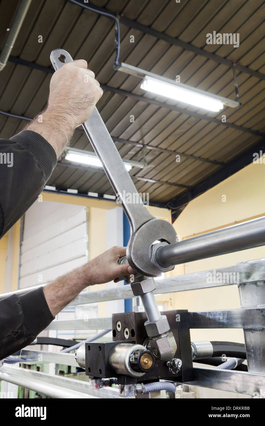 worker with a big wrench tweaking the screw Stock Photo Alamy