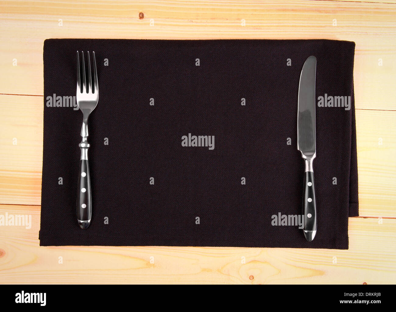 Fine cutlery on black placemat as menu board, top view Stock Photo