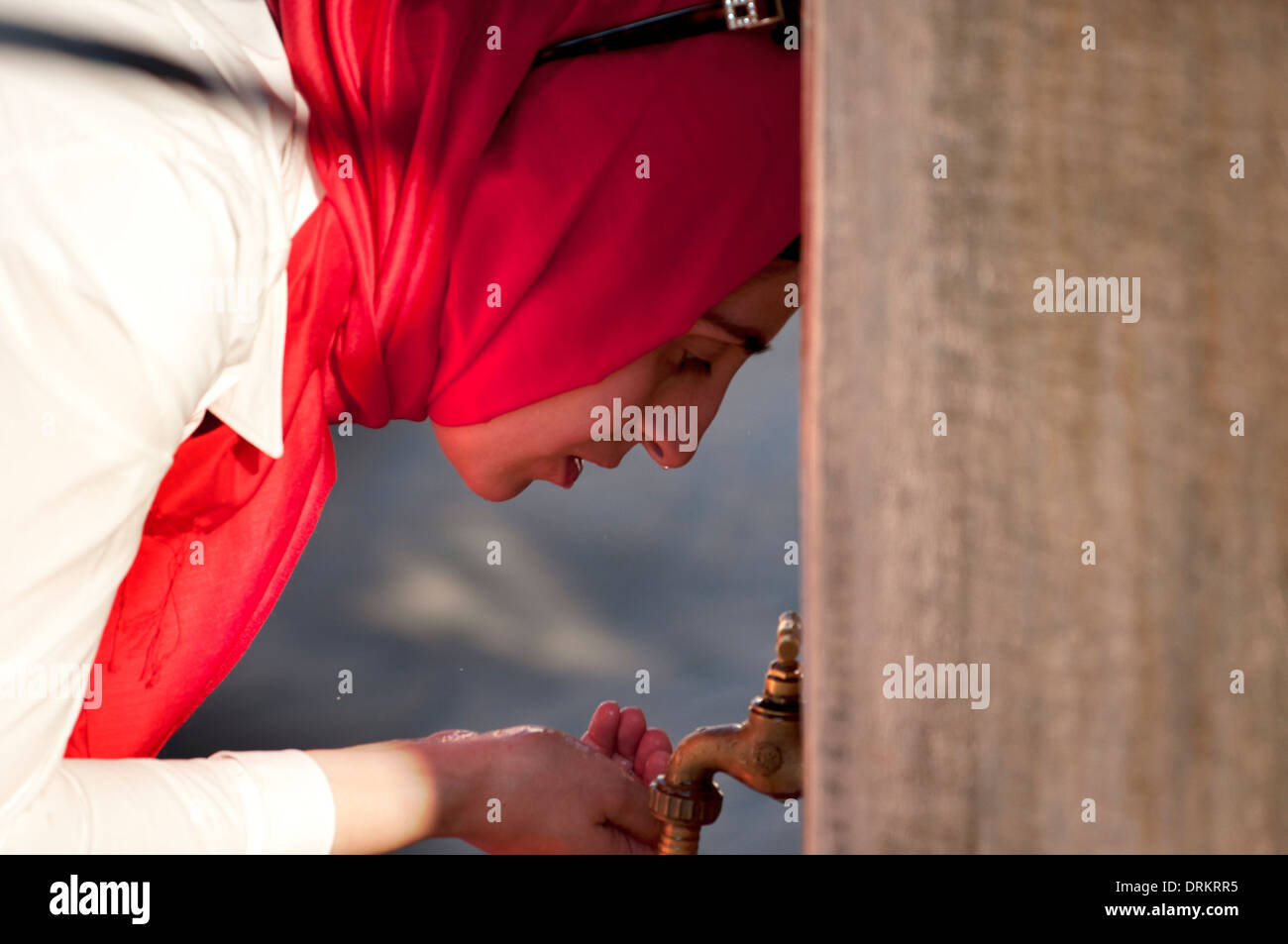 Muslim woman drinking from a fountain, Koski Mehmed Pasa Mosque, Mostar ...