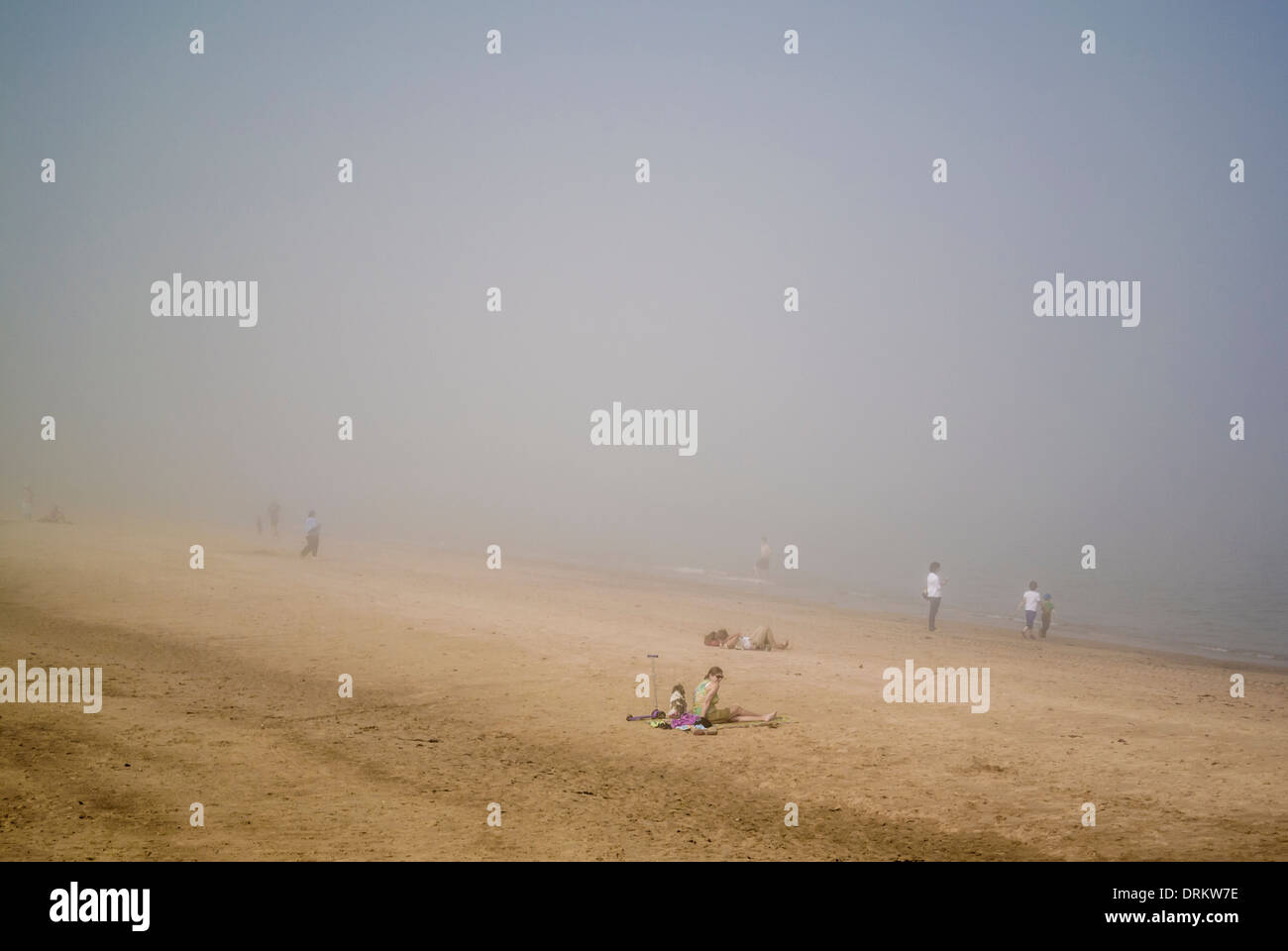 People on the beach at Whitley Bay in a summer sea fret. North Tyneside. Stock Photo