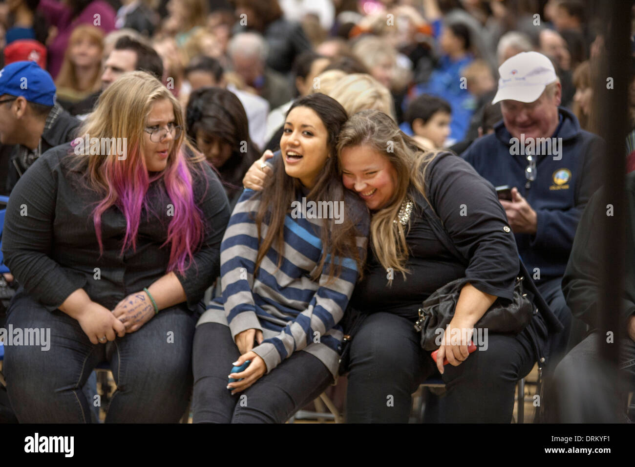 Two 'plus-size' teen girls share a laugh with a friend at a high school concert in Aliso Viejo, CA. Note purple hair. Stock Photo