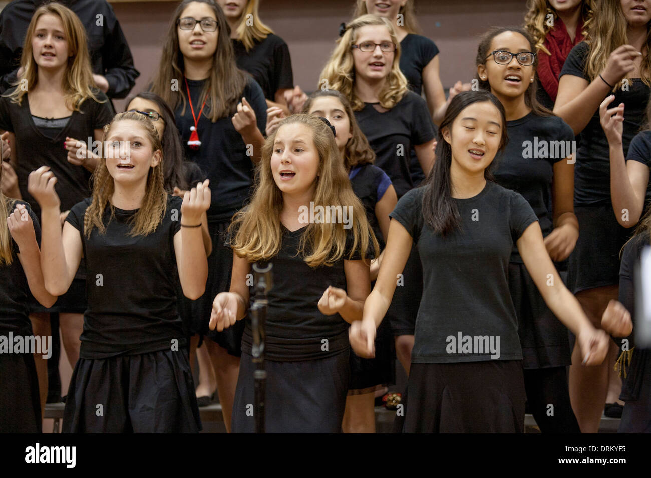 Multiracial middle school girls sings Christmas carols at a school concert in Aliso Viejo, CA. Note matching black clothing. Stock Photo