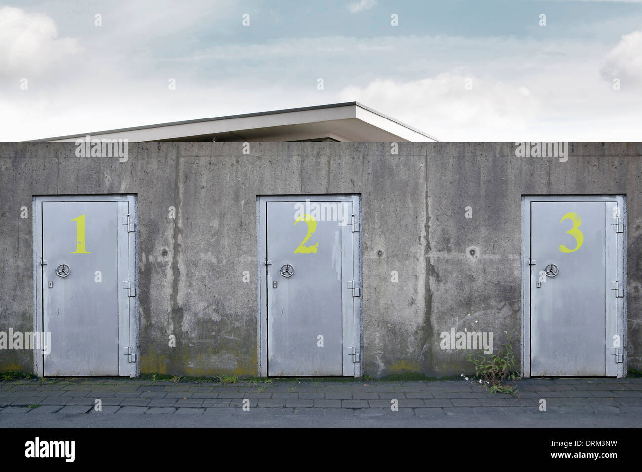 Building behind a wall with three safety doors, composing Stock Photo