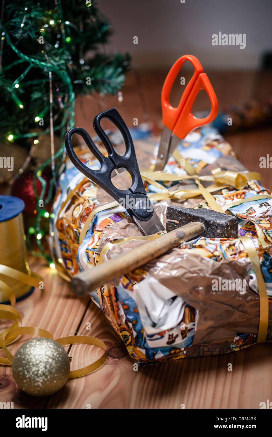 Bad packed Christmas gift spiked with scissors Stock Photo