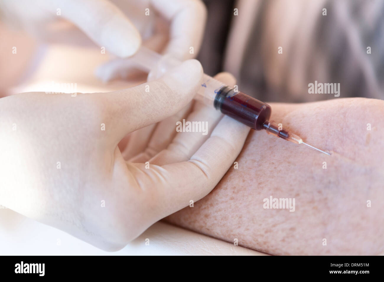 Female alternative practitioner taking a blood sample from senior woman Stock Photo