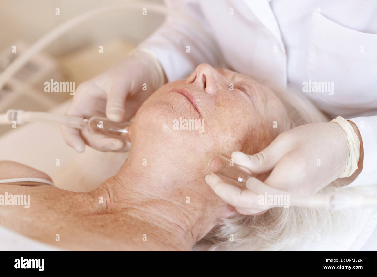 Female alternative practitioner treating senior woman with vacuum cupping therapy Stock Photo