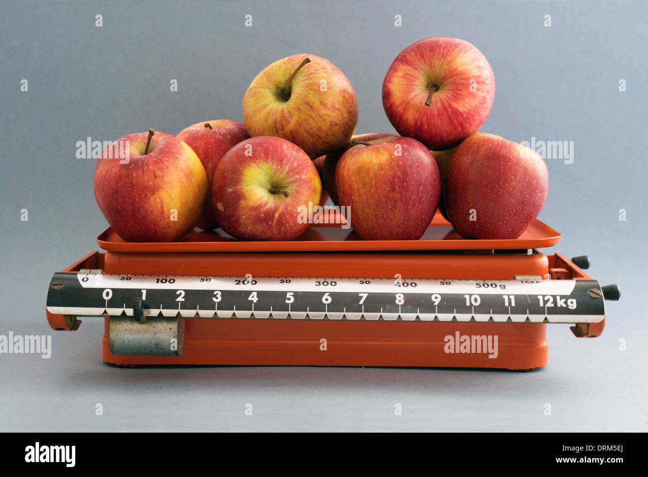 Red apples in vintage, antique kitchen scales Stock Photo