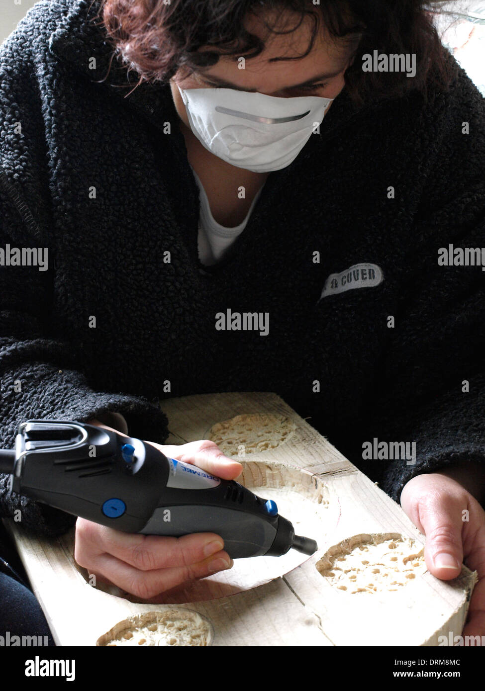 woman using a Dremel to carve wood, UK Stock Photo