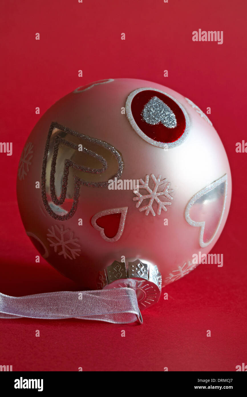 pink bauble hanging decoration with hearts on set on red background Stock Photo