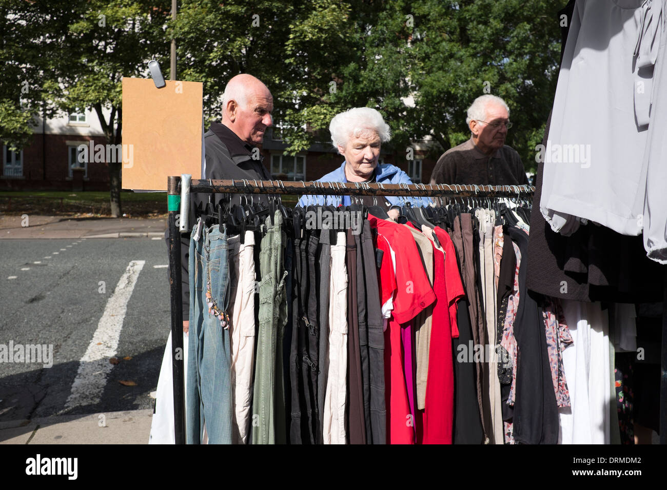 Old people looking through secondhand clothes rail Stock Photo