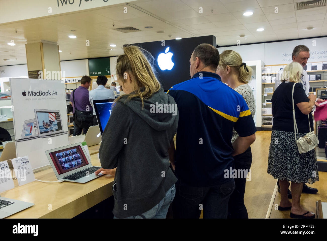 Shoppers trying out Apple products in John Lewis at the Mall at Cribbs Causeway, Bristol,  UK Stock Photo